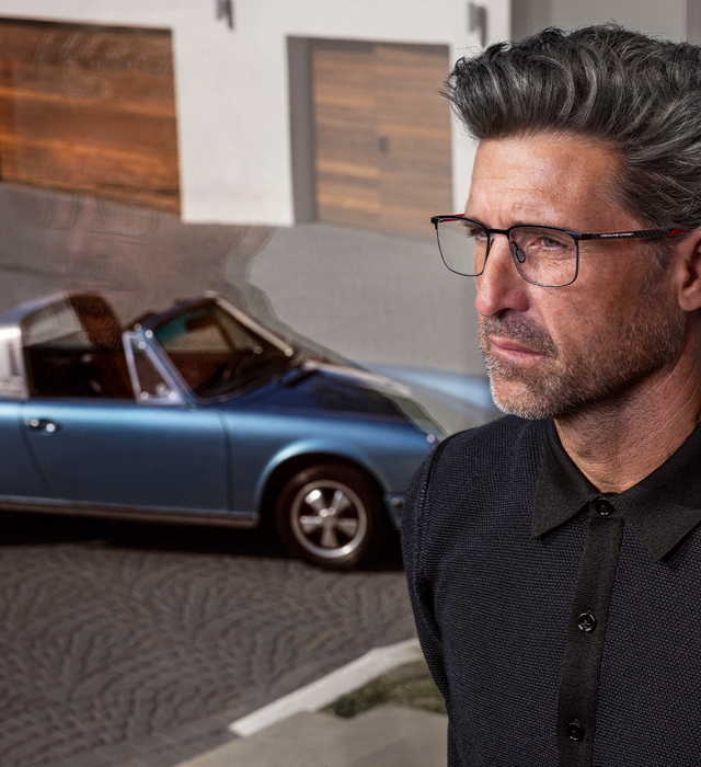 Shows Picture of Patrick-Dempsey-standing-at-window-wearing-porsche-design-glasses.png