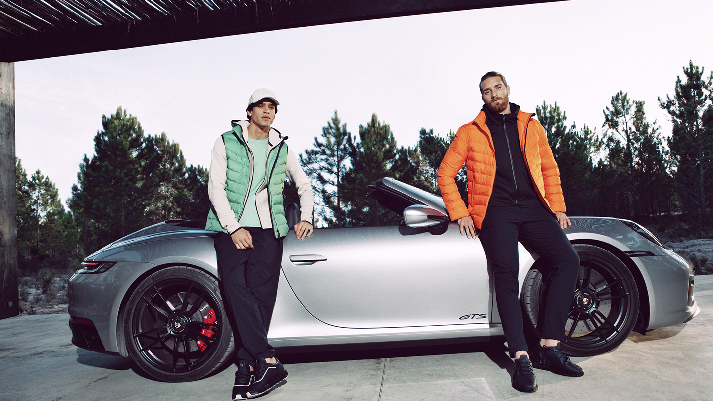 Shows Picture of Man_infront_Porsche_911GTS_Sportswear_Orange_Jacket_Green_Vest_Sneakers.png